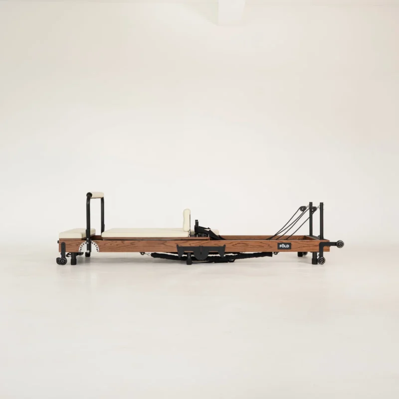FOLD Reformer Pilates bed in Red Oak and Beige PU leather