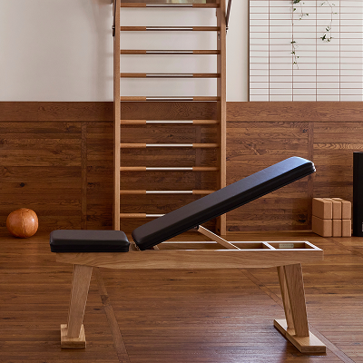 Leather and wood gym bench in wooden fitness room